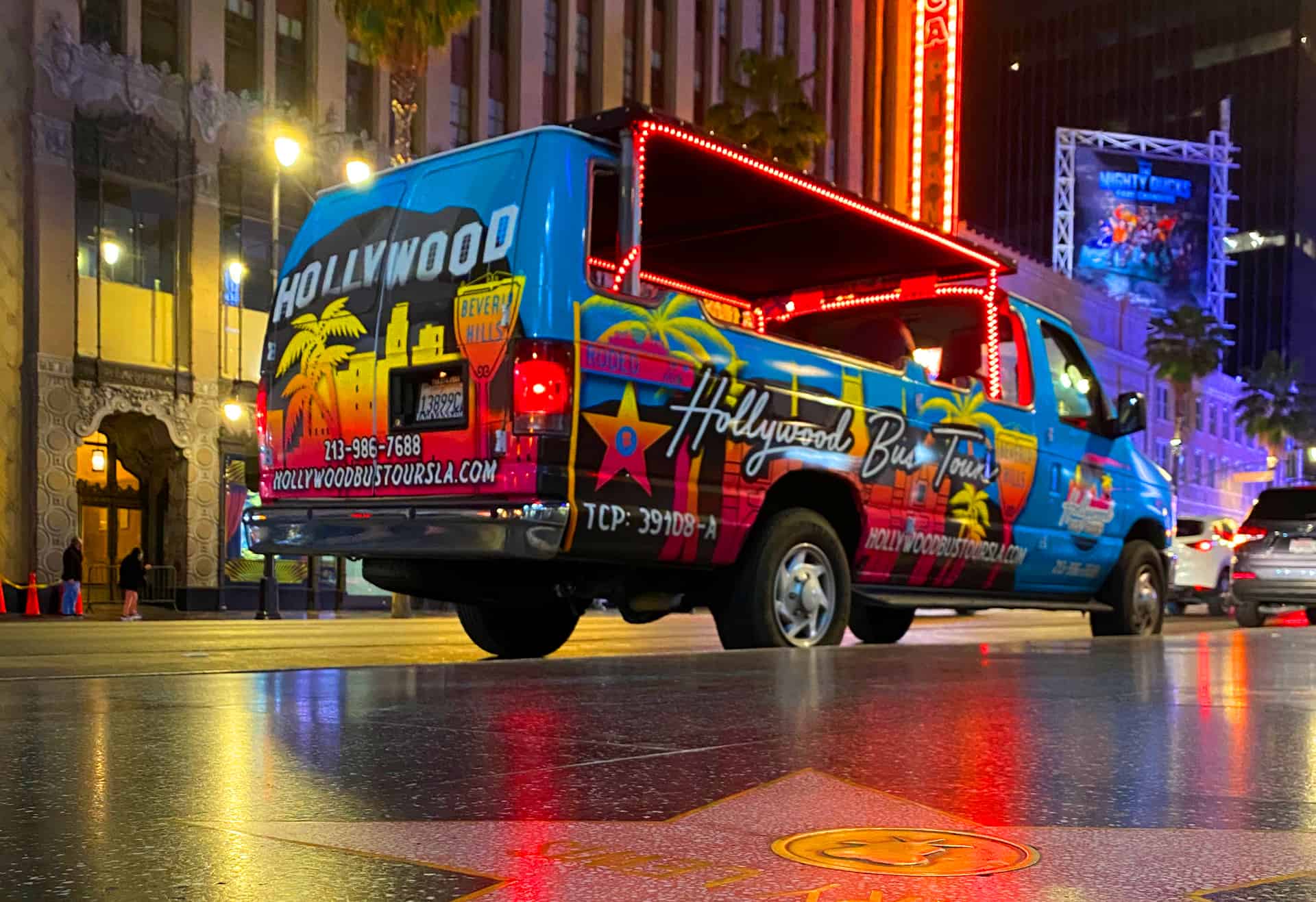 an image showing the hollywood bus tours van at night on hollywood boulevard