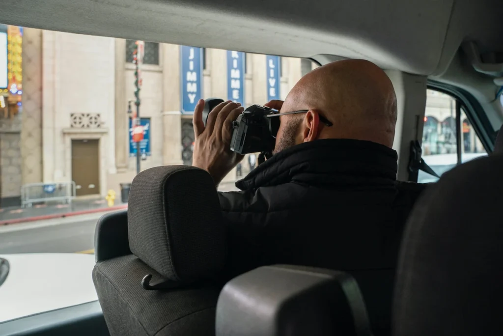 Man taking a photo out the window of a Hollywood Bus Tour