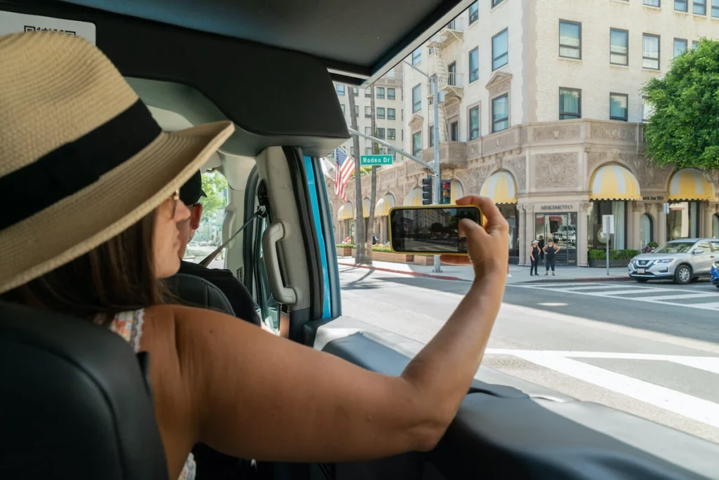 Woman Taking a photo out the window of a private hollywood bus tour