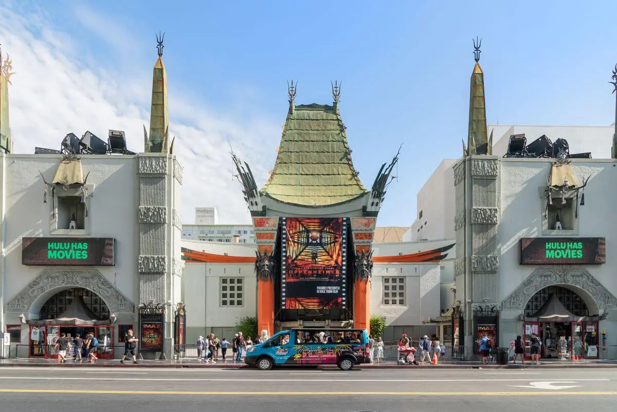 Front view of the TCL Chinese Theatre, showcasing its iconic Chinese-style architecture with ornate red and gold decorations, large red columns, intricate roof designs, and the famous forecourt area visible in front.