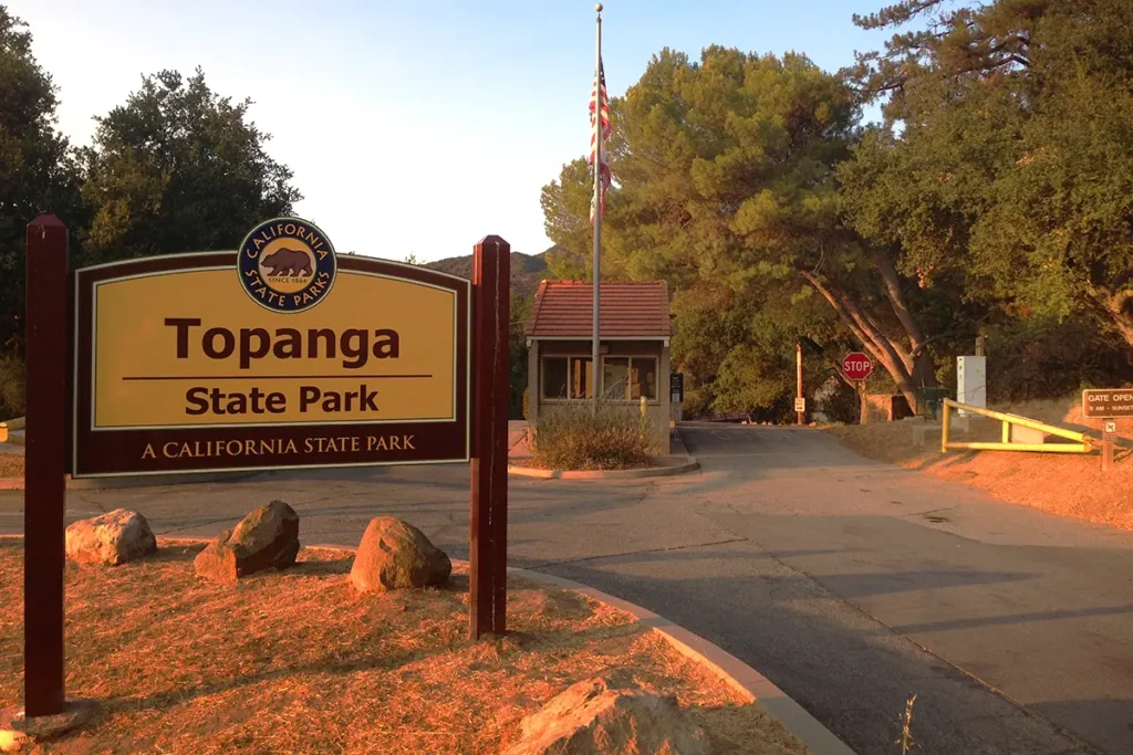Entrance sign of Topanga State Park with surrounding trees and natural landscape