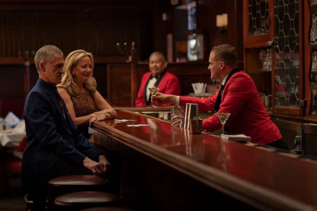 Alt Text: Bartender serving a guest at the historic Musso & Frank Grill in Hollywood.