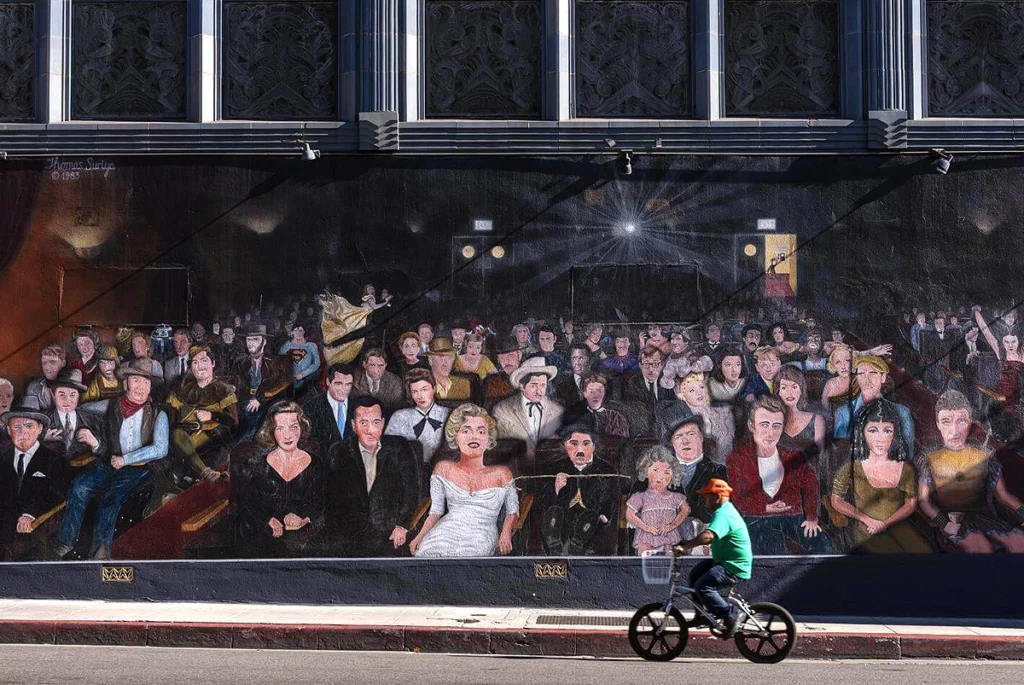 "You Are The Star" mural on Hollywood Boulevard with a cyclist passing by in the foreground.