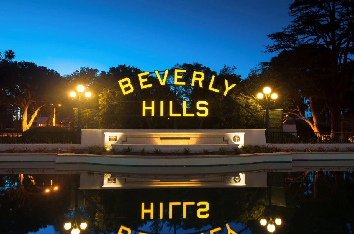 Beverly Hills iconic sign illuminated at night with reflection