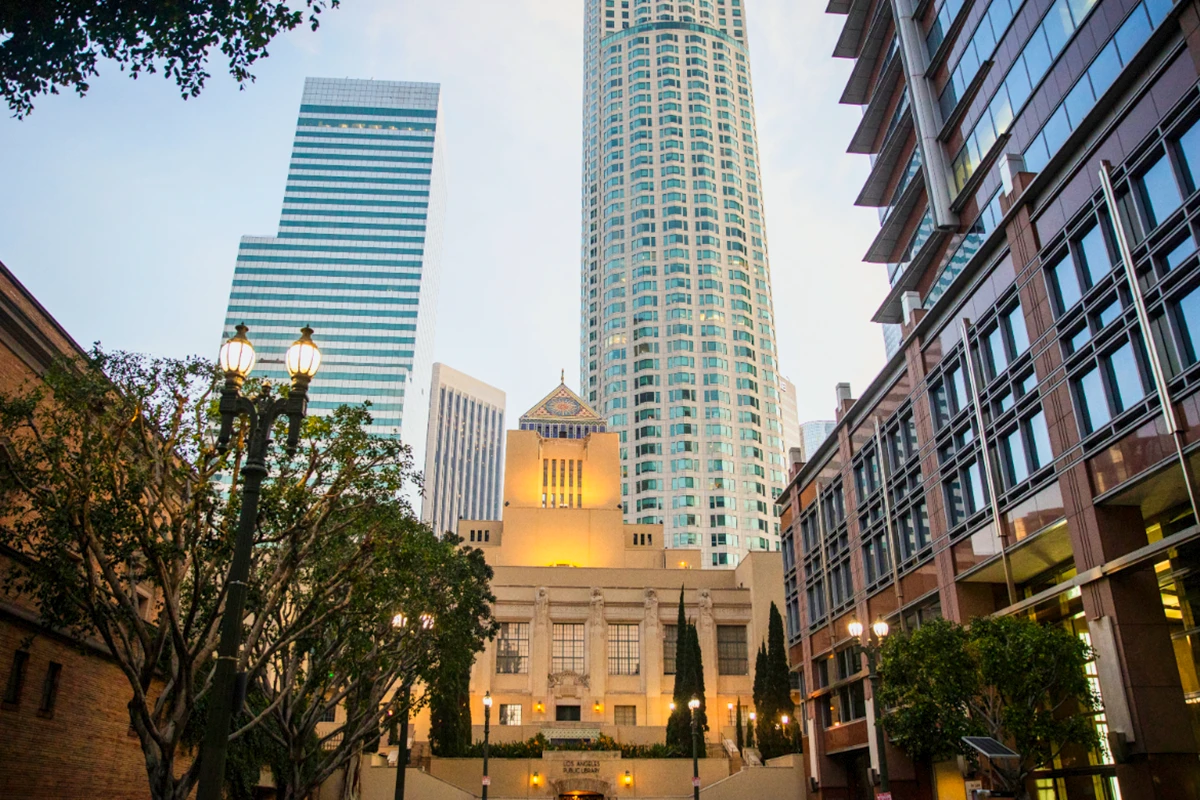 Los Angeles Central Library illuminated at dusk with skyscrapers