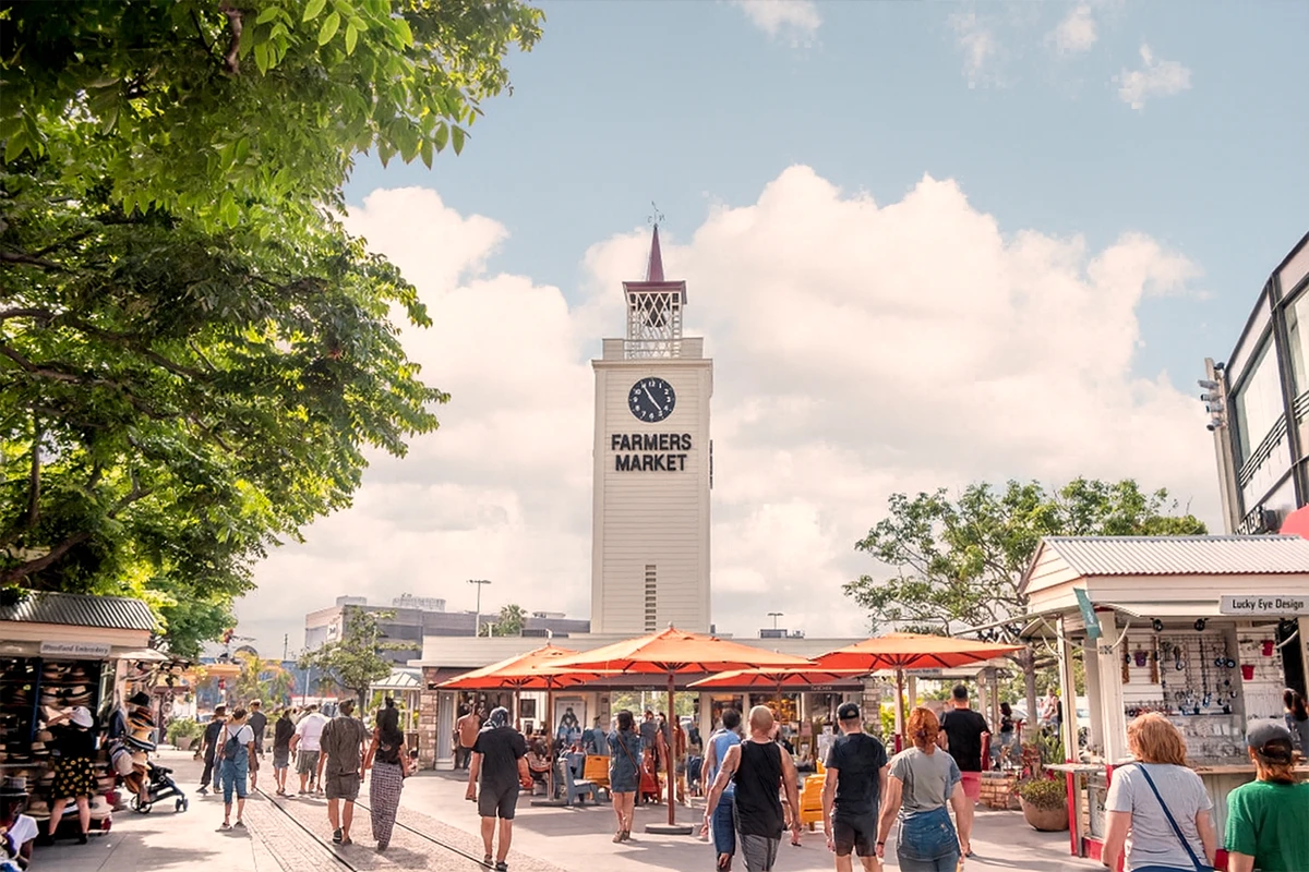 Historic Farmers Market clock tower with outdoor dining and crowds