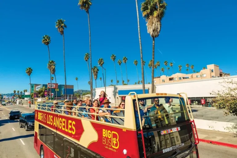 Tourists enjoying a Hollywood Big Bus hop-on hop-off tour with views of the Hollywood Sign in Los Angeles.