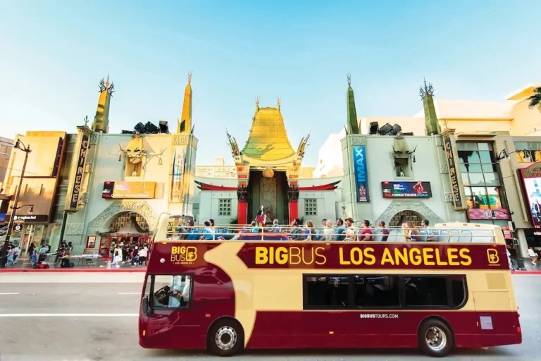 Hollywood hop-on hop-off Big Bus tour driving down Hollywood Boulevard near the Walk of Fame in Los Angeles.