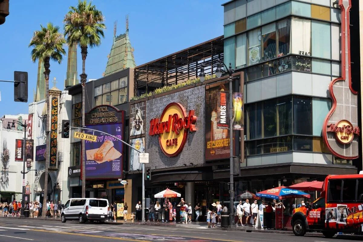Street view of Hollywood Boulevard featuring the Hard Rock Cafe, TCL Chinese Theatre, palm trees, and pedestrians
