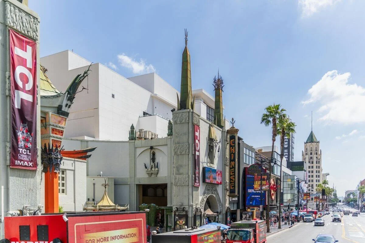 TCL Chinese Theatre on Hollywood Boulevard with crowds, theaters, and traffic along the Walk of Fame in Los Angeles