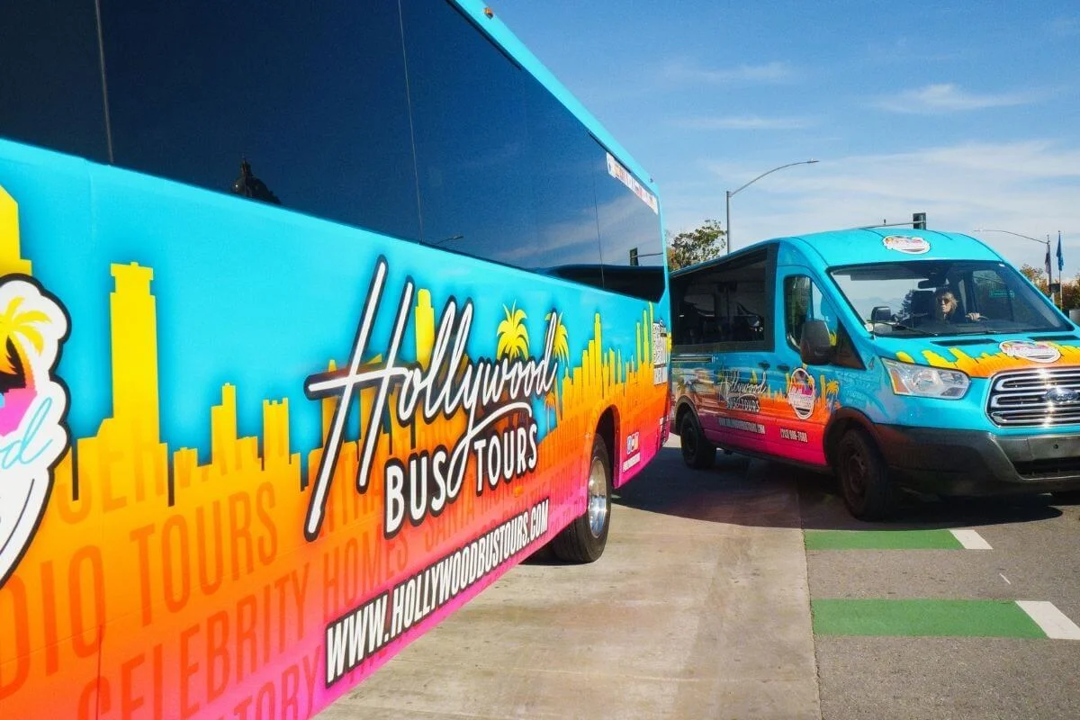 Colorful Hollywood Bus Tours vehicles parked on a street in Los Angeles for celebrity sightseeing tours