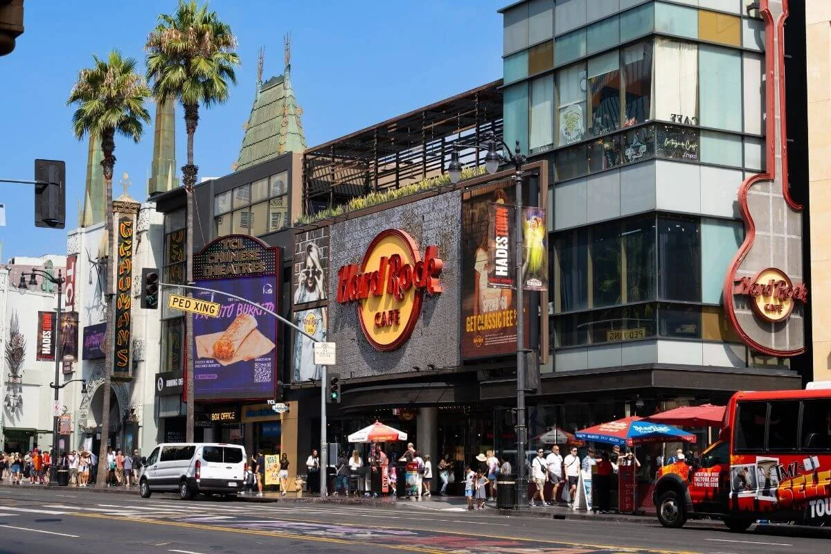 Street view of Hollywood Boulevard featuring Hard Rock Cafe, TCL Chinese Theatre, and tourists exploring the area in Los Angeles.