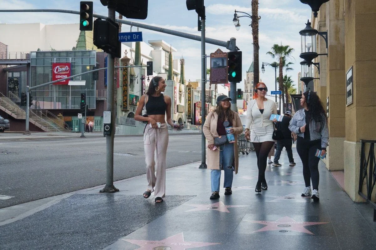 Group of friends walking along the Hollywood Walk of Fame in Los Angeles, enjoying a sightseeing tour in the city.