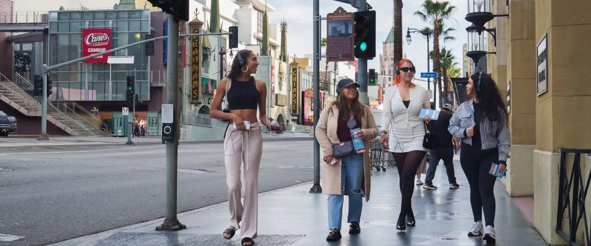 Group of friends walking along the Hollywood Walk of Fame in Los Angeles, enjoying a sightseeing tour in the city.