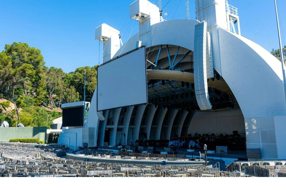 Close-up of the Hollywood Bowl shell stage with empty seats and large screen on a sunny day