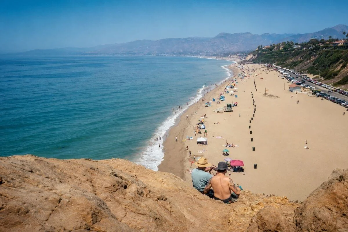 Visitors enjoying a Pacific Coast Highway overlook during a Malibu day trip from Los Angeles