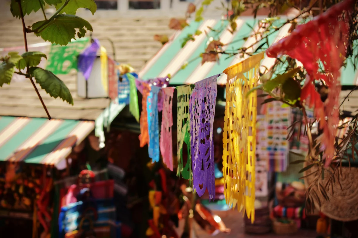 Colorful papel picado banners hanging above a market stall on Olvera Street in Los Angeles