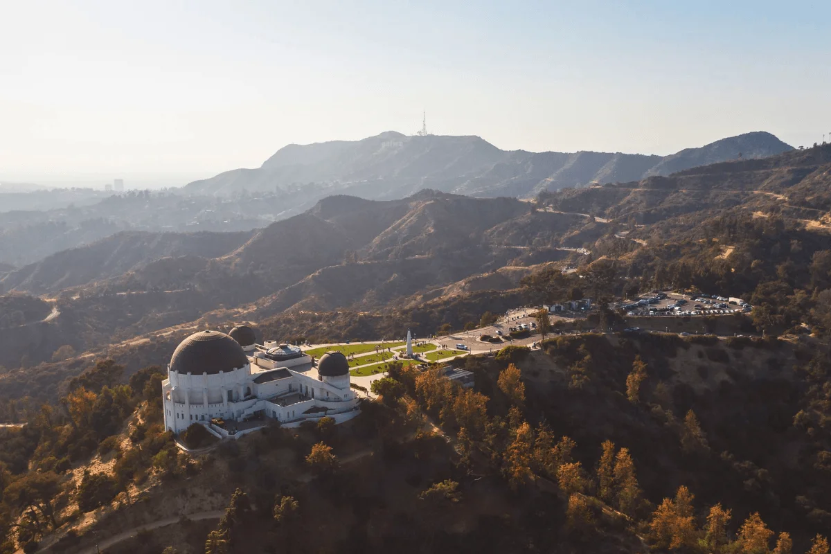 Aerial view of Griffith Observatory surrounded by the hills and trails of Griffith Park