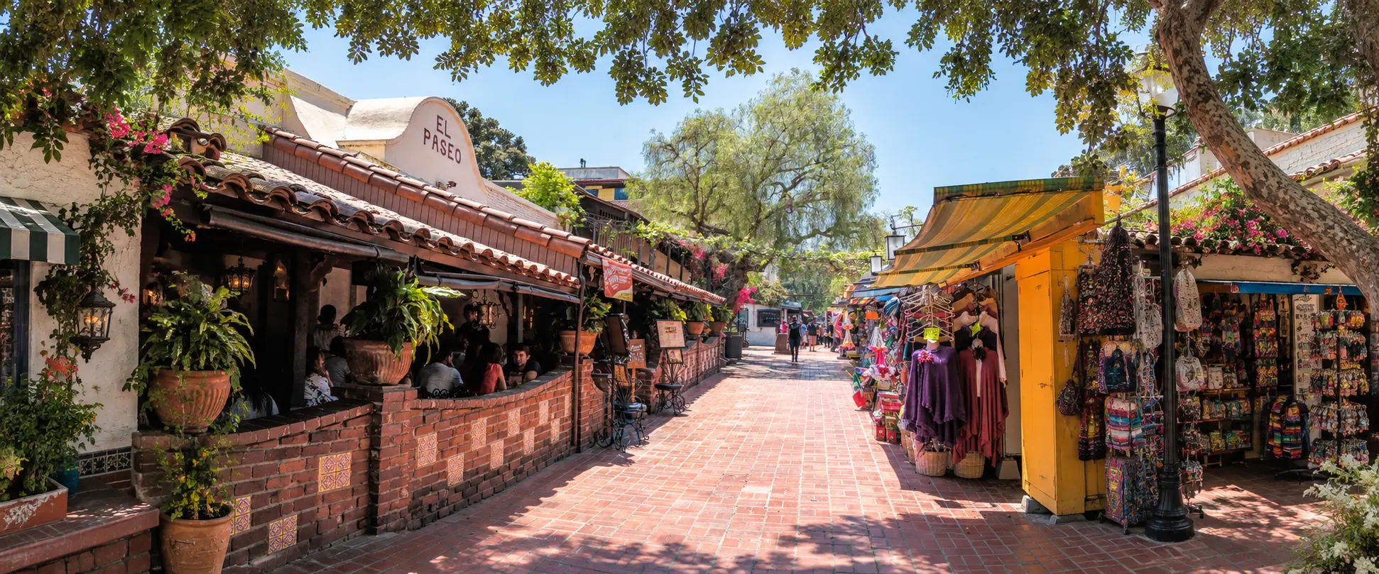 Shaded brick promenade on Olvera Street with El Paseo restaurant’s tiled patio on the left and colorful vendor stalls on the right